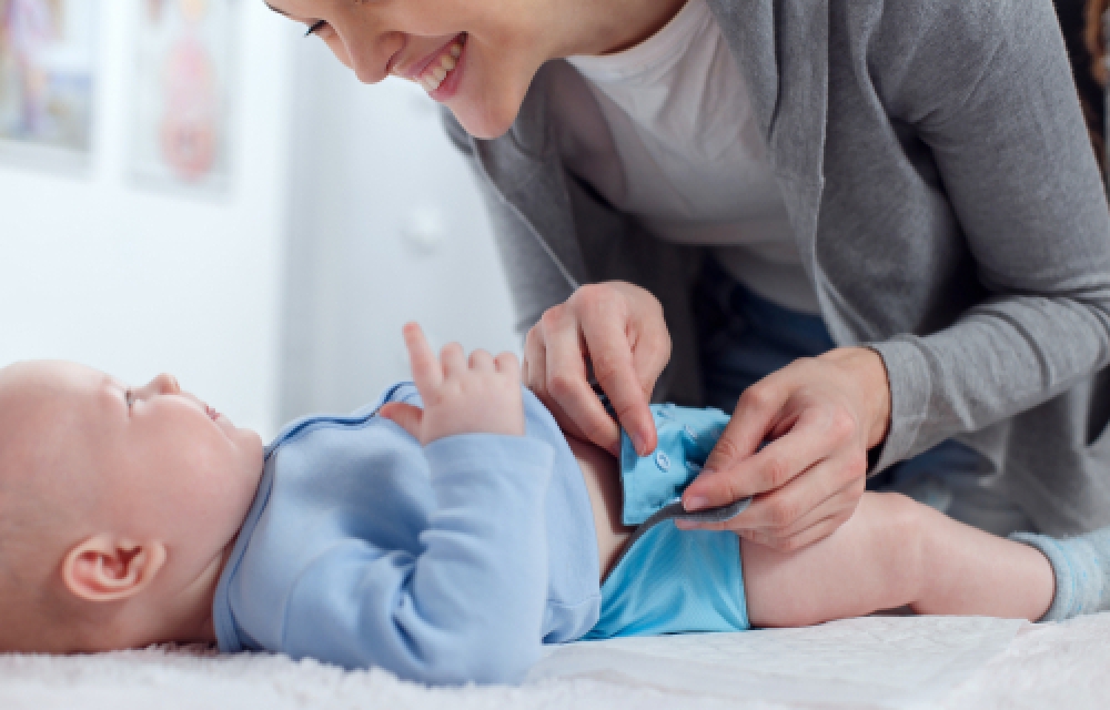 Baby being buttoned into reusable nappy