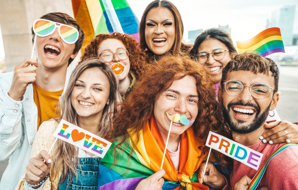 image of a group of happy people with pride flags and signs