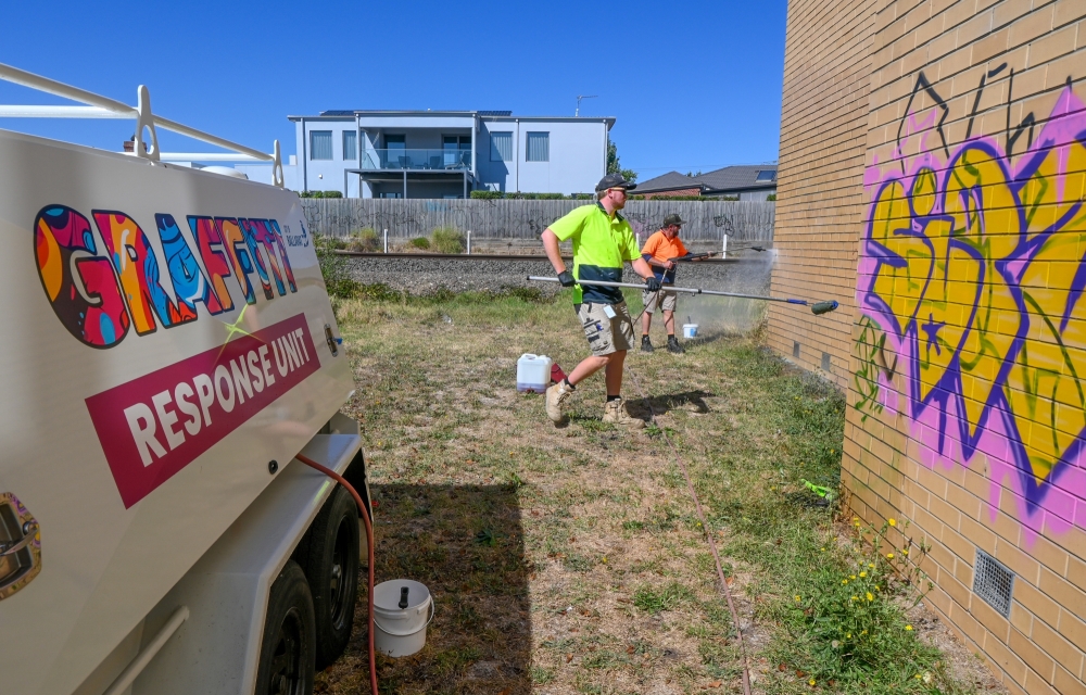image of the City of Ballarat graffiti response unit cleaning graffiti off a brick wall