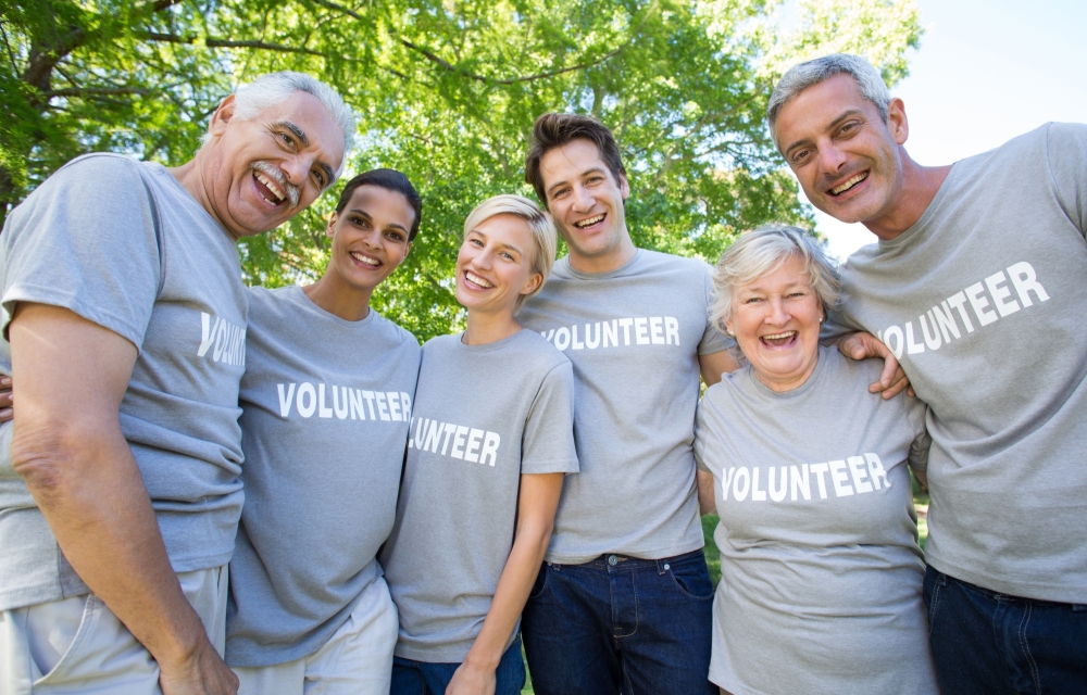 Happy volunteer family smiling at the camera on a sunny day