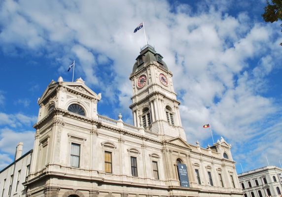 The image looks up at Ballarat Town Hall with a blue sky dotted with clouds in the background.