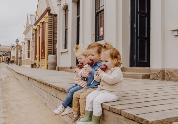 Generic photo group of children sitting on a step eating toffee apples