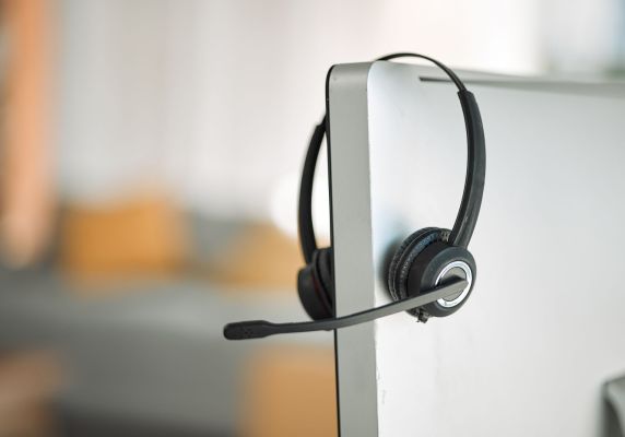 image of headset hanging over a computer screen