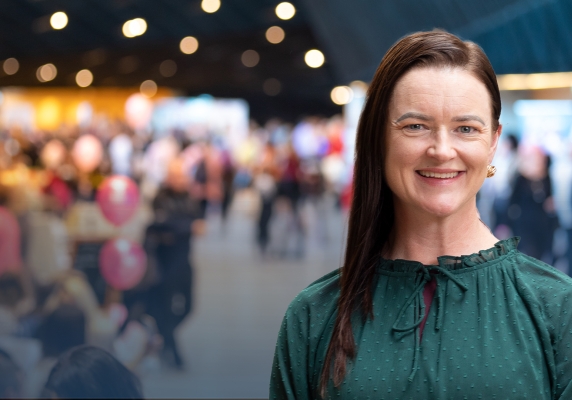 Image of Mayor Cr Tracey Hargreaves in front of a blurred image of an expo