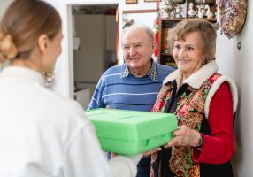 Elderly couple receiving a meal at doorstep