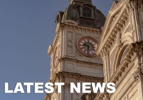 Town hall clock up close with "latest news" written at the bottom