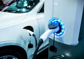 An electric vehicle is plugged into an electric vehicle charging station. 