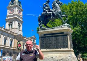 Mayor Cr Des Hudson standing in front of the Boer War Memorial Statue in Sturt Street with Town Hall in the background.