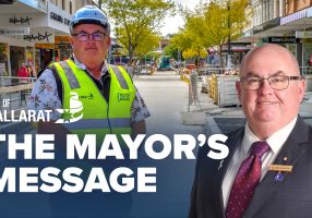 Text with The Mayor's Message with an image of Mayor Cr Des Hudson in front of the ongoing Bridge Mall redevelopment