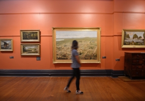 Image of a girl walking through the gallery admiring the artwork