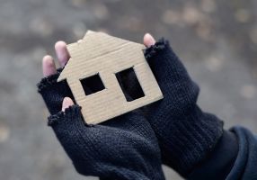 Hands holding a small cardboard house