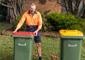 Image of person putting bins out