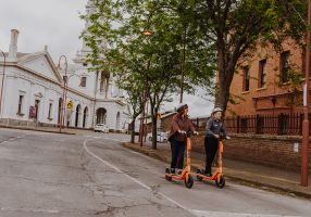 City of Ballarat Visitor Economy Executive Manager Sarah Pilgrim and Visitor Services Officer Paul Mifsud explore Ballarat on e-scooters.