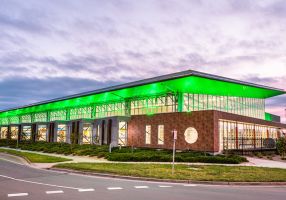 Exterior photo of BALC with green lighting at dusk