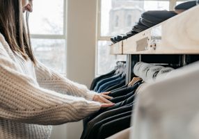 A woman looking through clothes on a rack