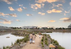 people walking on a path between two bodies of water