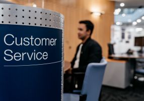 customer service sign with person sitting in the background