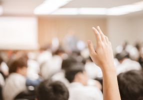 A hand raised during a meeting