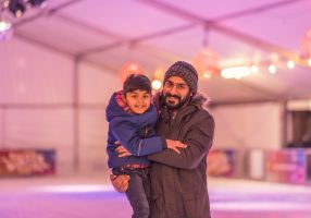 A man and a young girl enjoying the ice skating rink at Winter Festival