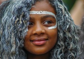 close up of a young indigenous girl with white paint on her face