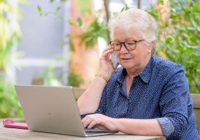 Women over 50 at a laptop while one the phone 