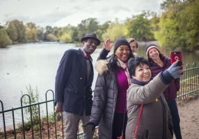 A group of older people take a photo by a river